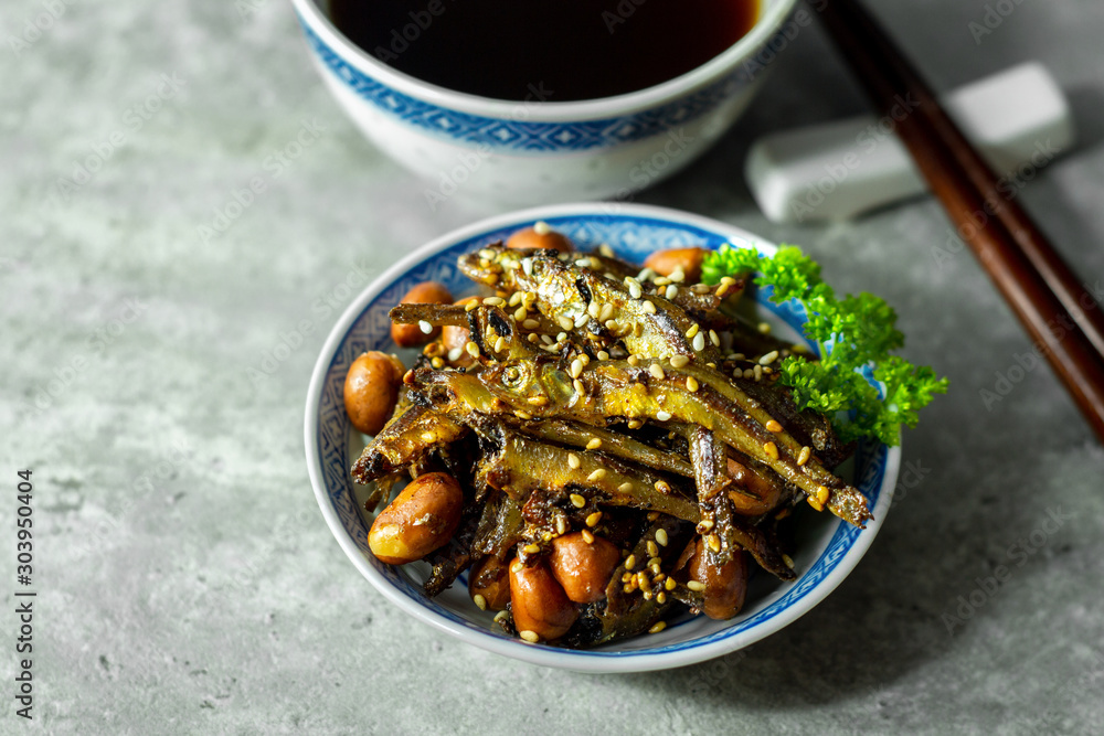 Tazukuri, candied sardines served with a hot steep black tea. Dried sardines lightly coated with honey, roasted sesame and peanuts. Tazukuri, candied sardines served with a hot steep black tea. Dried sardines lightly coated with honey, roasted sesame and peanuts.