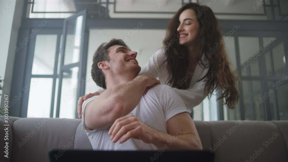 Closeup businessman working laptop at home. Sexy woman massaging man Closeup businessman working laptop at home. Sexy woman massaging man