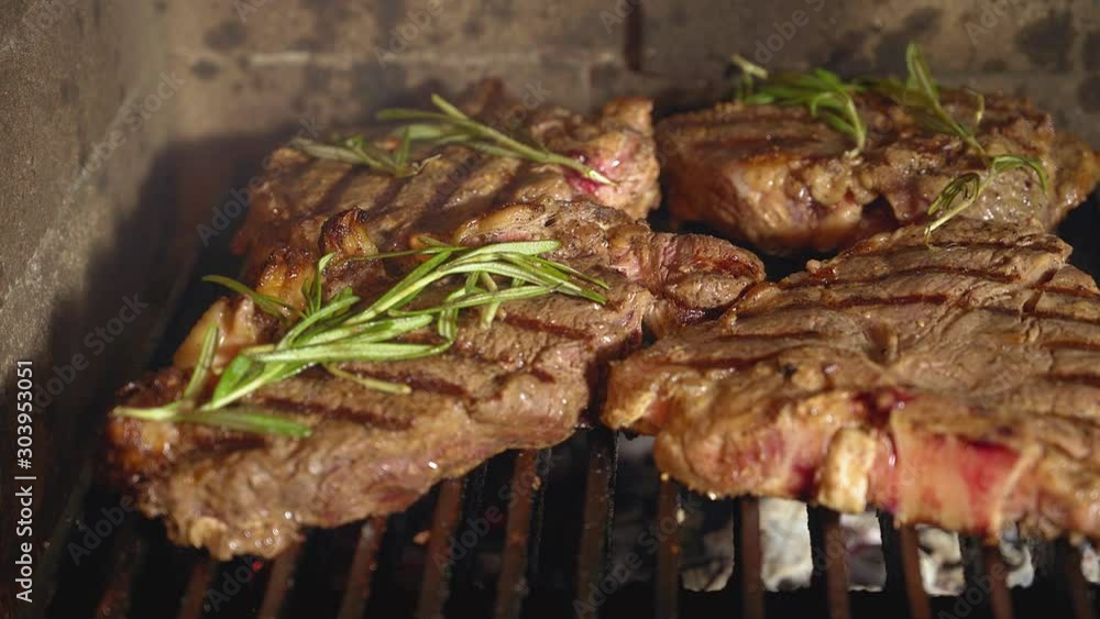 Grilling steaks, meat with the addition of herbs and spices on the grill. Grilled meat, bbq, barbecue Grilling steaks, meat with the addition of herbs and spices on the grill. Grilled meat, bbq, barbecue