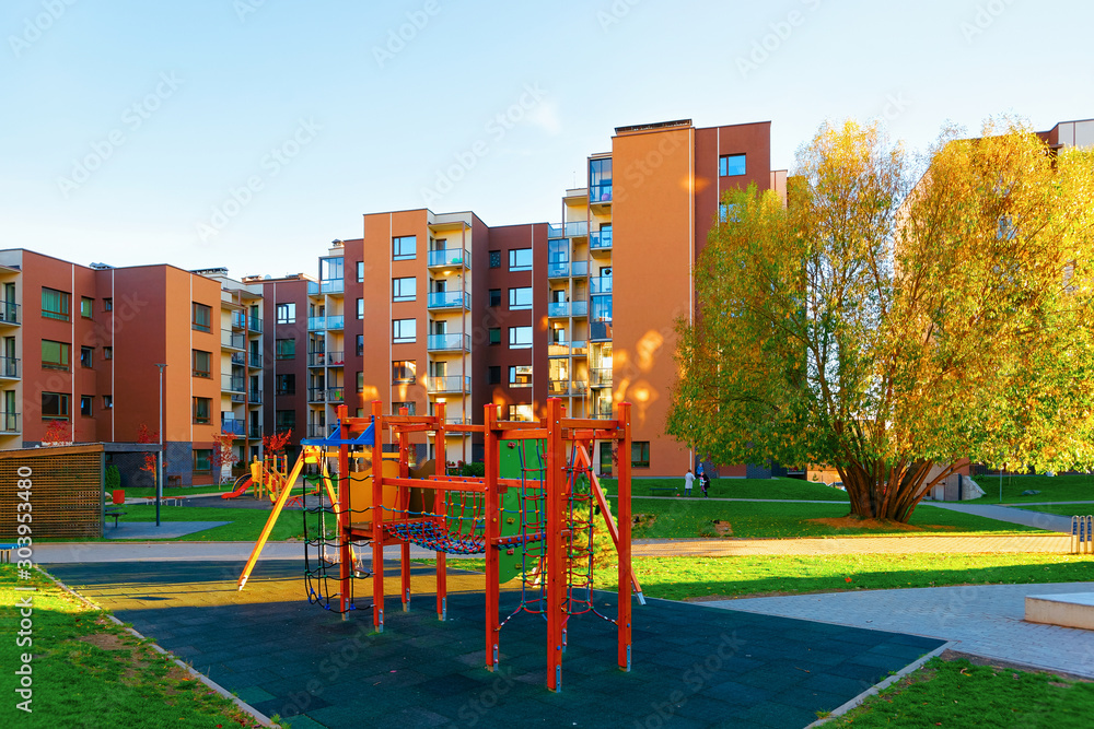 Apartment residential house facade architecture with children playground and outdoor facilities. Blue sky on the background. Apartment residential house facade architecture with children playground and outdoor facilities. Blue sky on the background.