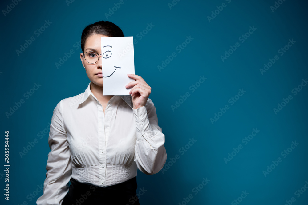 Φωτογραφία emotional girl in glasses and a white shirt covers half of her face with a piece