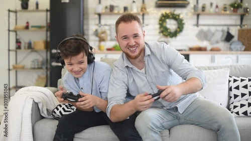 Father and son funny playing on game console photo