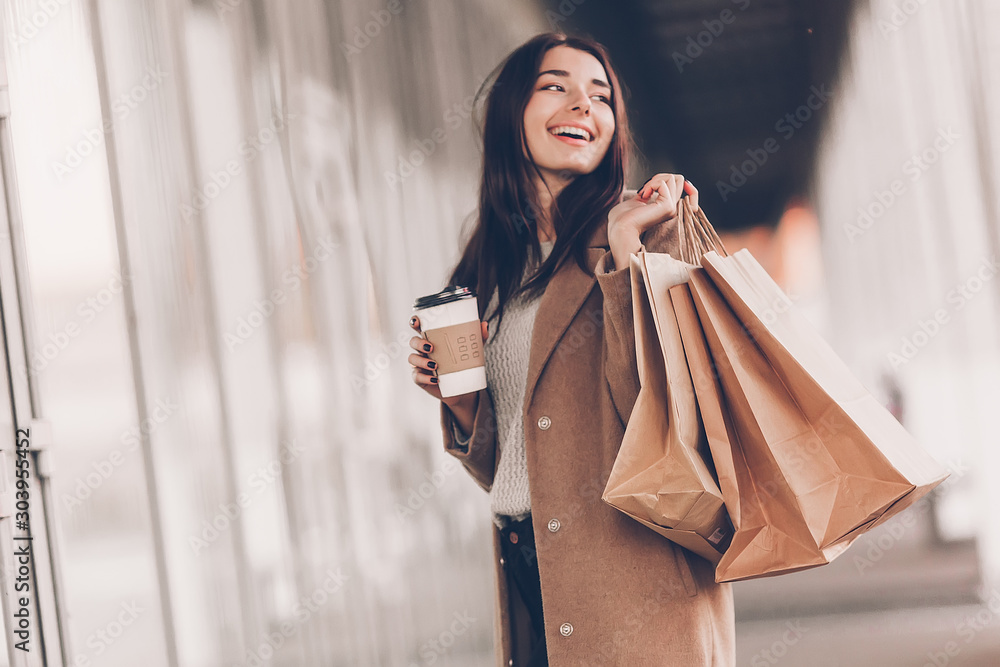 Φωτογραφία Beautiful fashionable woman with shopping bags and coffee walking near mall