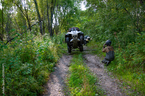 ATV jumps on the rear wheels in the forest in summer.