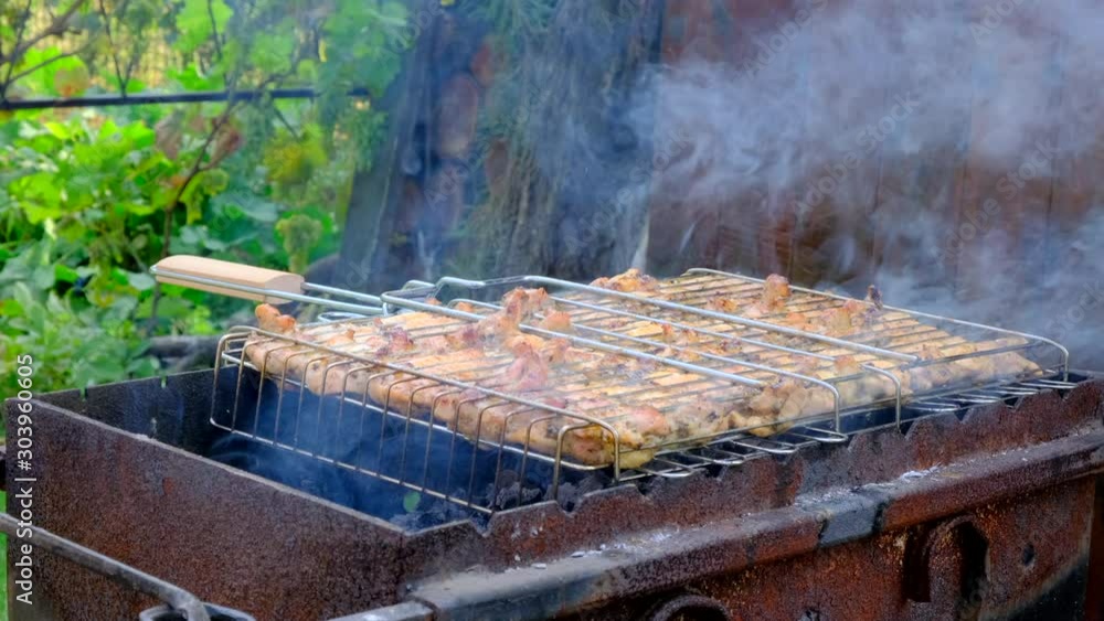 Chicken meat fried on a barbecue grill, outdoors. Preparing Street food. Tasty and Marinated chicken Meat on grill. Grilling and frying fresh popular food Chicken meat fried on a barbecue grill, outdoors. Preparing Street food. Tasty and Marinated chicken Meat on grill. Grilling and frying fresh popular food