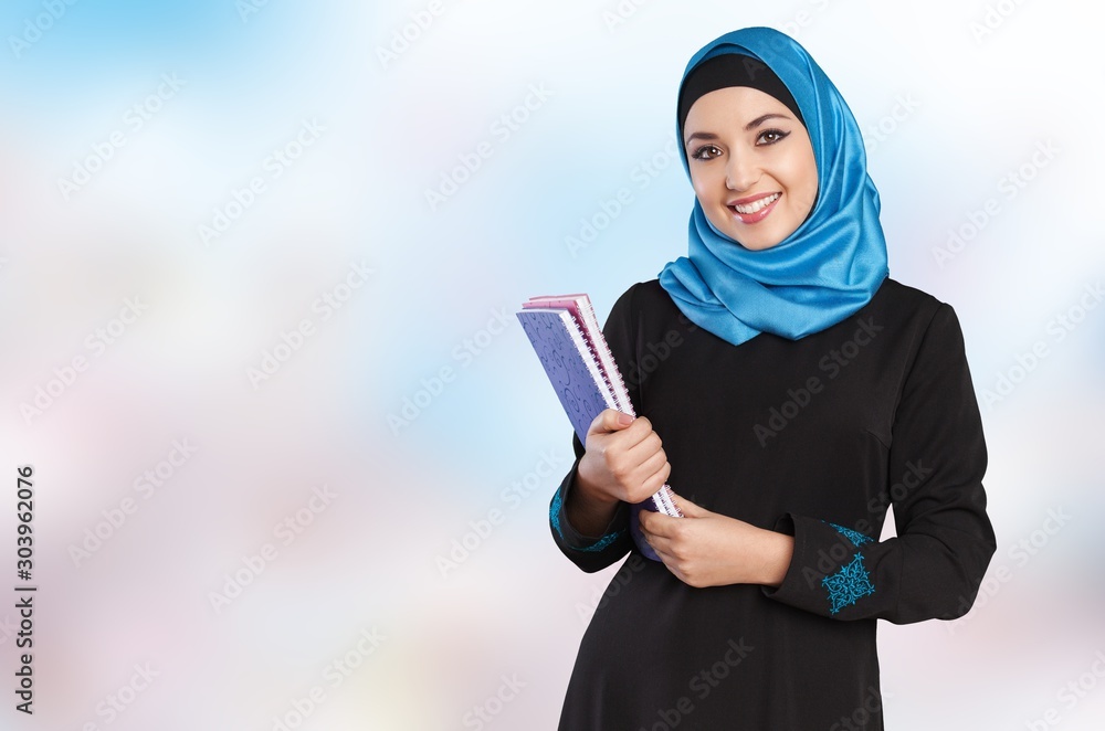 Close-up Beautiful Young Muslim Woman with notebooks on blurred background Close-up Beautiful Young Muslim Woman with notebooks on blurred background