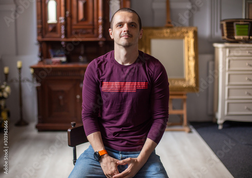 Portrait of man sitting at home in modern interiour