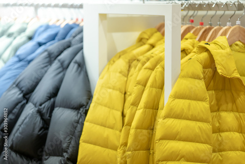 Multi colors winter jacket hang on clothes hanger in department stores.