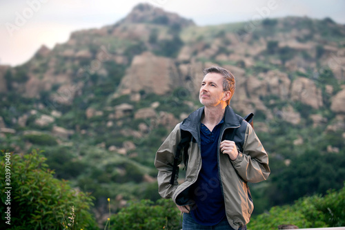 Middle aged man staying healthy by doing outdoor activities during a nature getaway vacation.  He is hiking through the mountains and enjoying the peace and serenity.