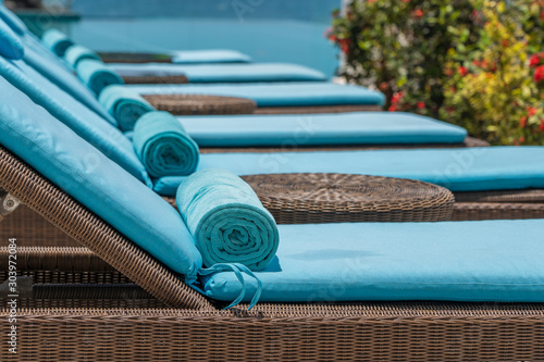 Fotografia, Obraz Closeup of towels on lounge chairs near a luxury swimming pool at a tropical res