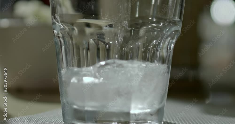 Water in a glass with ice cubes in it. Fresh cold mineral sparkling water in tall glass. Water in a glass with ice cubes in it. Fresh cold mineral sparkling water in tall glass.
