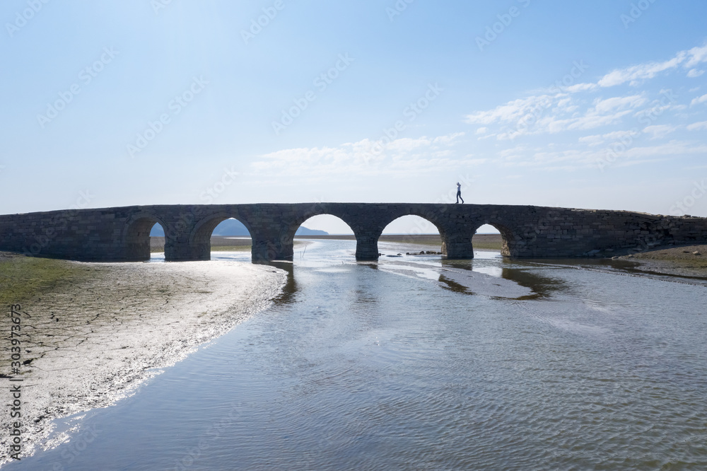 beautiful ancient stone arch bridge against a blue sky