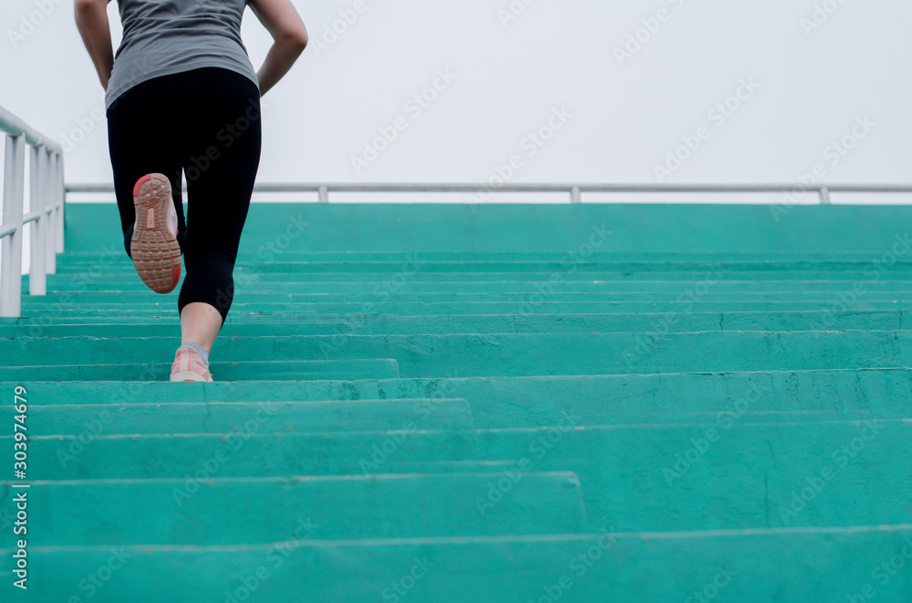 Φωτογραφία Woman runner feet exercising to running on stairway in gym , She is jogging, fit