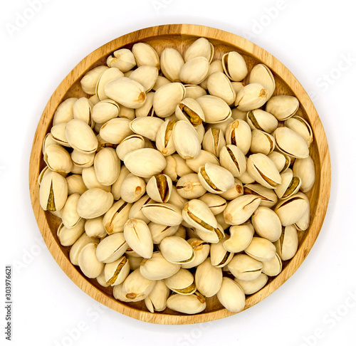 pistachios in wooden bowl  isolated on white background