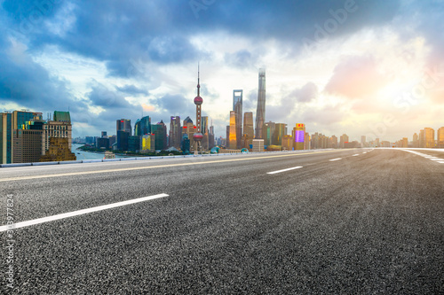 Empty asphalt highway and modern cityscape in Shanghai at sunset.