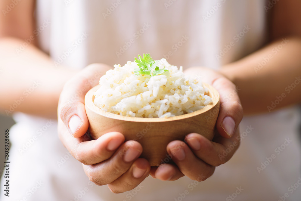 Cooked rice with quinoa seed in bowl holding by hand - obrazy, fototapety, plakaty 