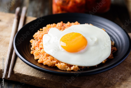 Kimchi fried rice with fried egg on top and chopsticks, Korean food