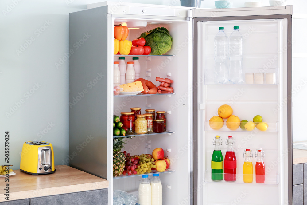 Open big fridge with products in kitchen Open big fridge with products in kitchen