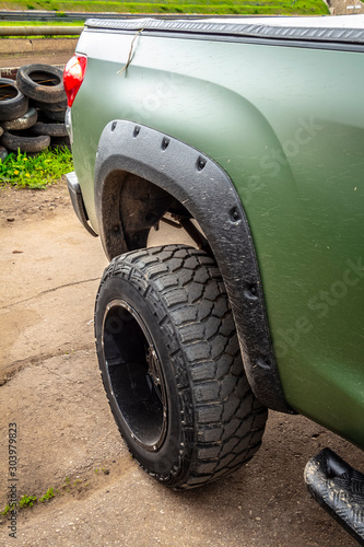 Wheel of green offroad pickup truck close-up.