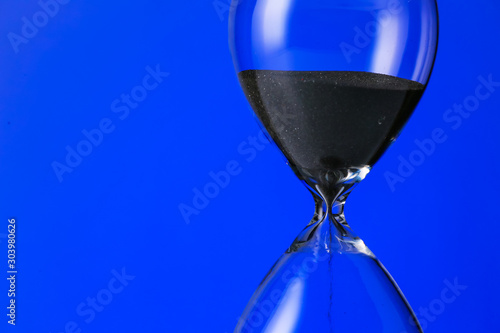 Crystal hourglass on color background