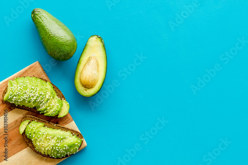 Healthy food. Avocado toast on blue background top view frame copy space