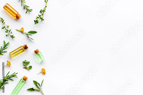 Essential oils and fresh herbs on white background top view pattern frame copy spacee