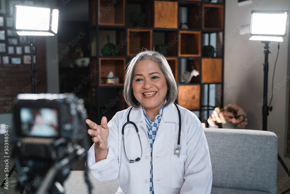 Φωτογραφία Senior female doctor recording video for his blog about healthy life