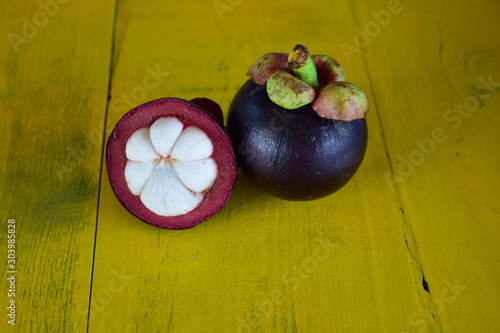 Mangosteen (Garcinia mangostana Linn), the famous fruit of Thailand, has been named as the queen of fruit which placed on a wooden table was shelled can see the flesh inside, white, appetizing.