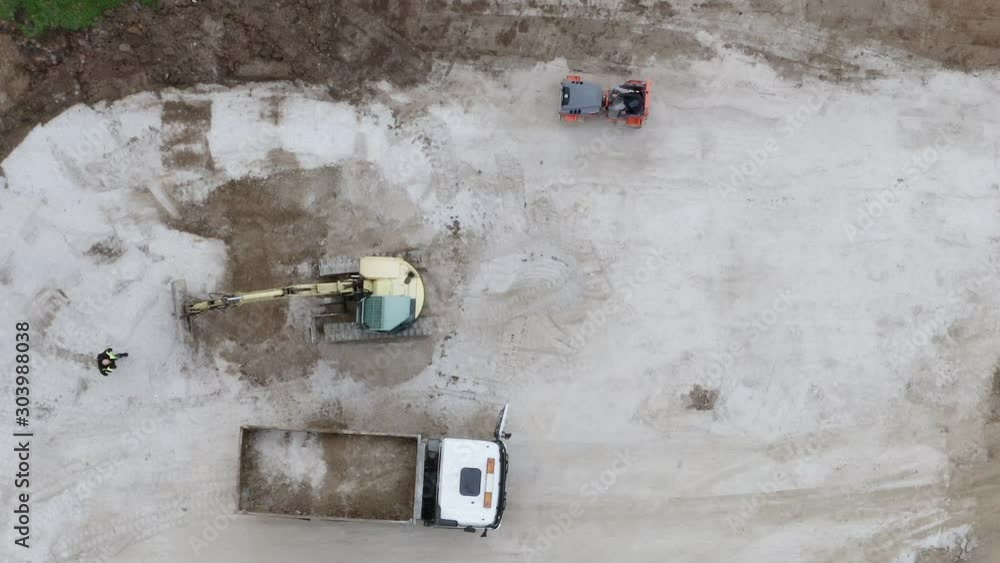 Excavator preparing construction site. Aerial birds eye, static Excavator preparing construction site. Aerial birds eye, static