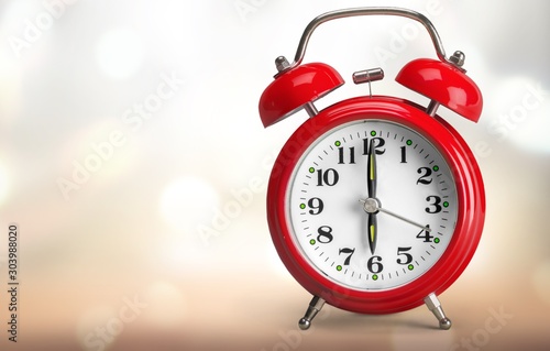 Retro red alarm clock on abstract background