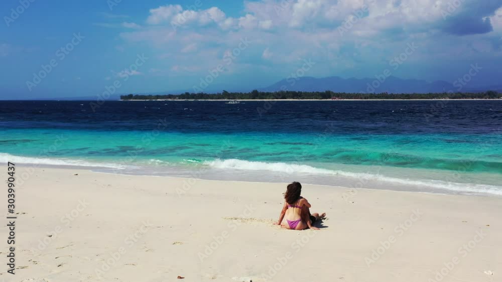 Romantic couple relaxing on the bright white sandy beach while enjoying the scenery of the turquoise water near the shoreline of Fiji Island - running shot Romantic couple relaxing on the bright white sandy beach while enjoying the scenery of the turquoise water near the shoreline of Fiji Island - running shot