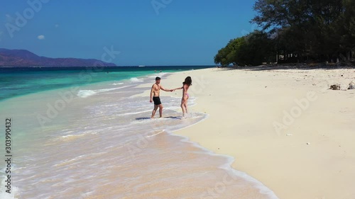 A Happy Couple Enjoying Each Others Company While Walking At The Shore In Naviti Island - Wide Shot photo