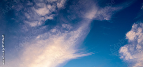 Beautiful pastel colored clouds at sunset isolated against blue skies