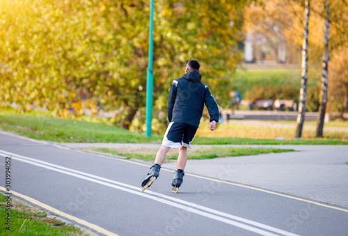 The guy rides on roller skates in the autumn Park