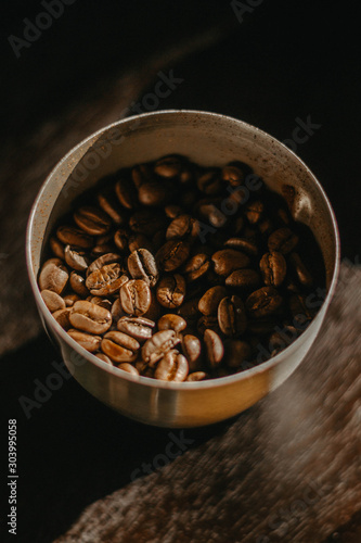 cup of coffee with beans on wooden table