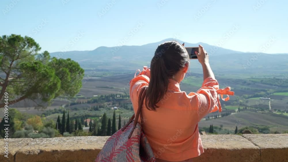 Female Tourist Taking Photos of Amazing Tuscan Landscape in Sunny Weather. Vacation in Italy. Concept of Holidays and World Travel Concept Female Tourist Taking Photos of Amazing Tuscan Landscape in Sunny Weather. Vacation in Italy. Concept of Holidays and World Travel Concept