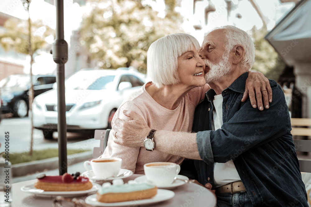 Nice grey haired man kissing his wife Nice grey haired man kissing his wife