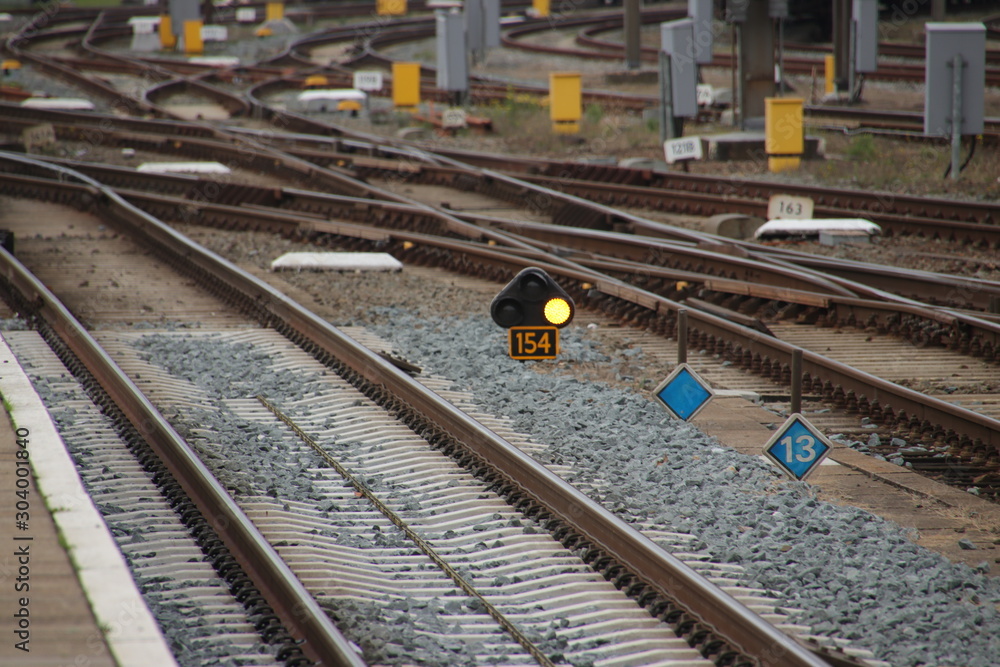 Orange sign light between railroad tracks at Amersfoort station which means speed reduction Orange sign light between railroad tracks at Amersfoort station which means speed reduction