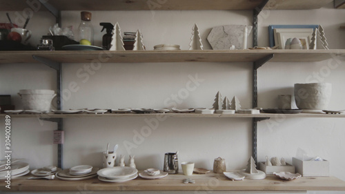 Сlay products and earthenware stand on shelves in a pottery workshop