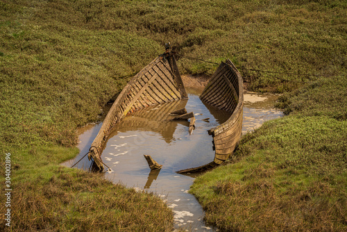 Fotografie The wreck of a boat in the grass, seen in Askam-in-Furness, Cumbria, England, UK