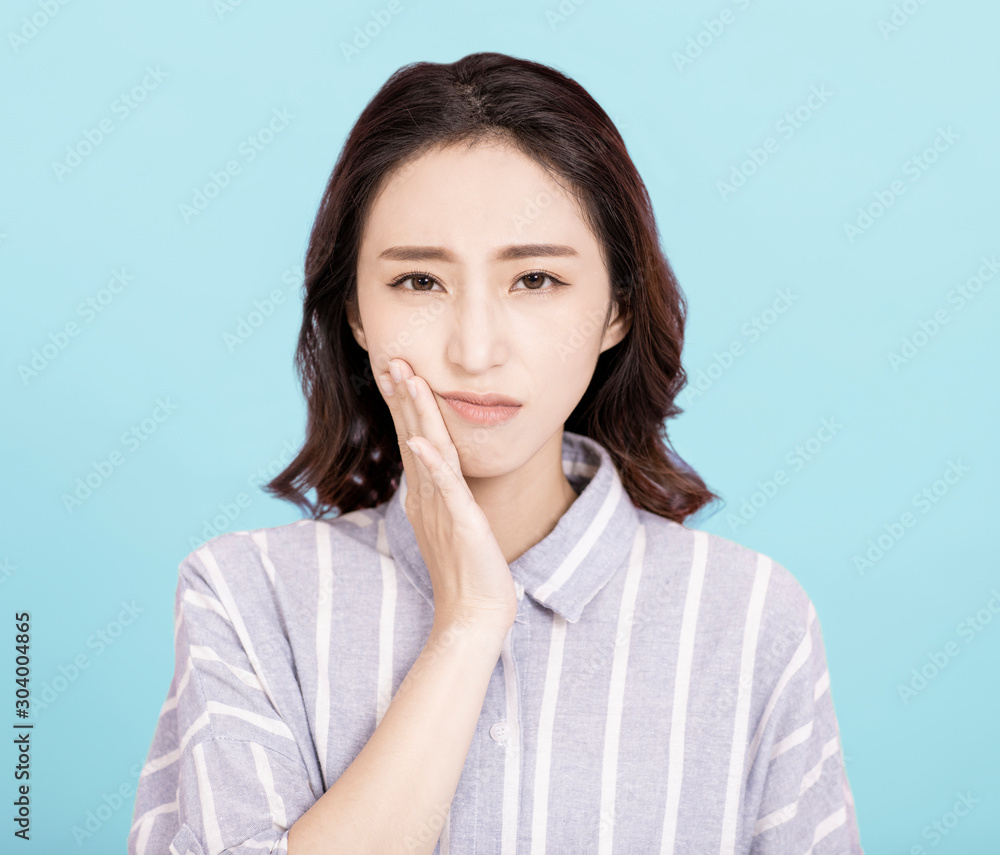 young woman touching mouth with hand with painful expression young woman touching mouth with hand with painful expression
