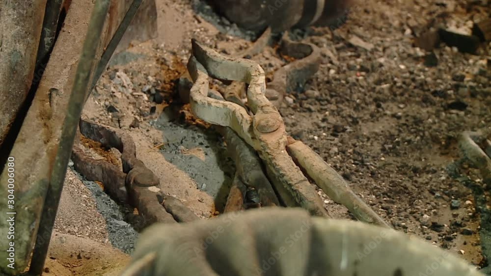 blacksmith tongs lying on ashes in front of ancient traditional oven, focus shift blacksmith tongs lying on ashes in front of ancient traditional oven, focus shift
