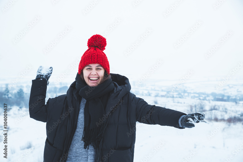 young smiling woman throwing snowball. playing outdoors in snowy weather young smiling woman throwing snowball. playing outdoors in snowy weather