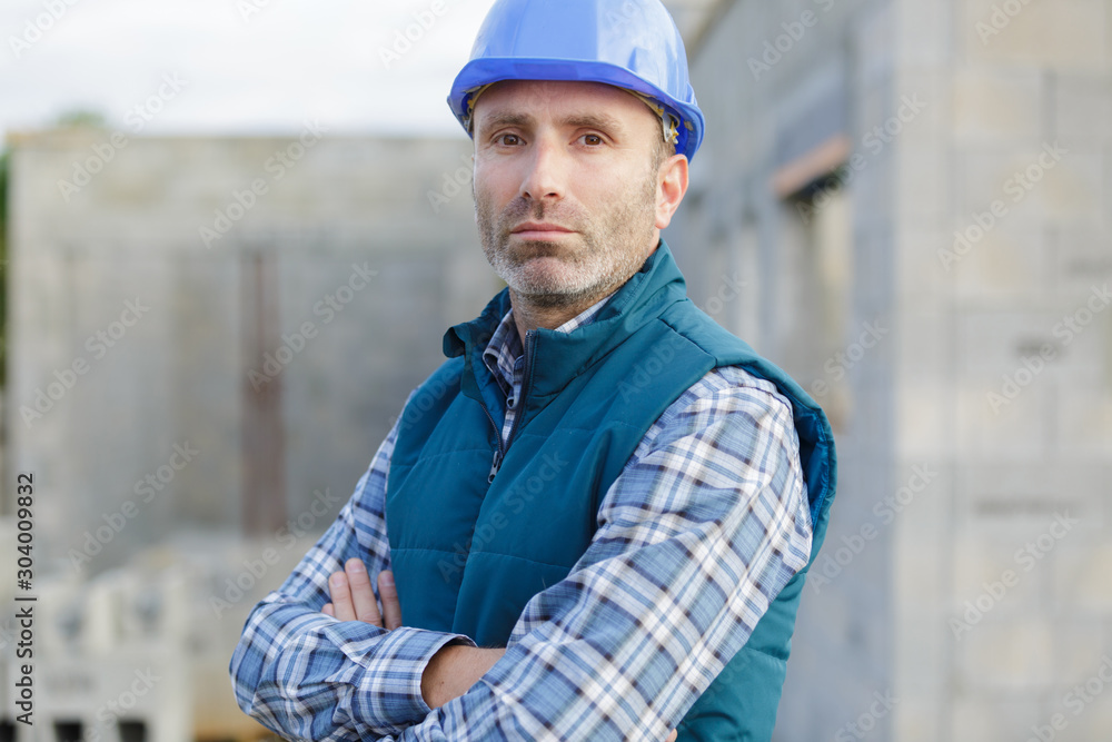 portrait of confident mid adult manual worker with arms crossed portrait of confident mid adult manual worker with arms crossed