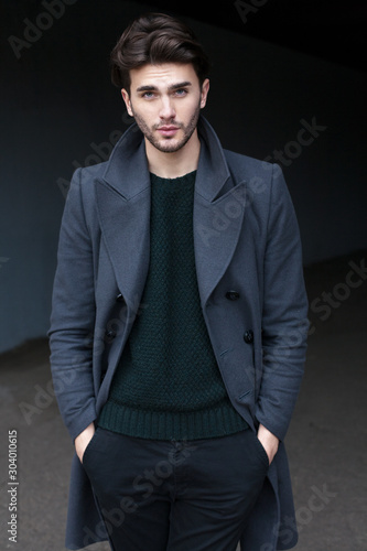 Outdoor portrait of handsome young man in coat