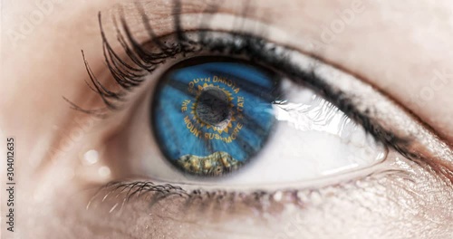 Woman green eye in close up with the flag of South Dakota state in iris, united states of america with wind motion. video concept photo