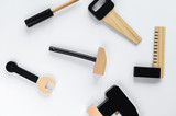 Children wooden instruments on a white background, a hammer in the center of the composition. The concept of diy