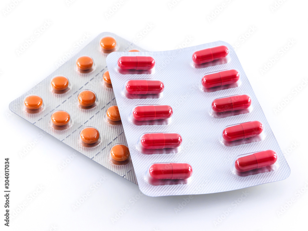 Two packages of red and orange tablets on a white background Two packages of red and orange tablets on a white background