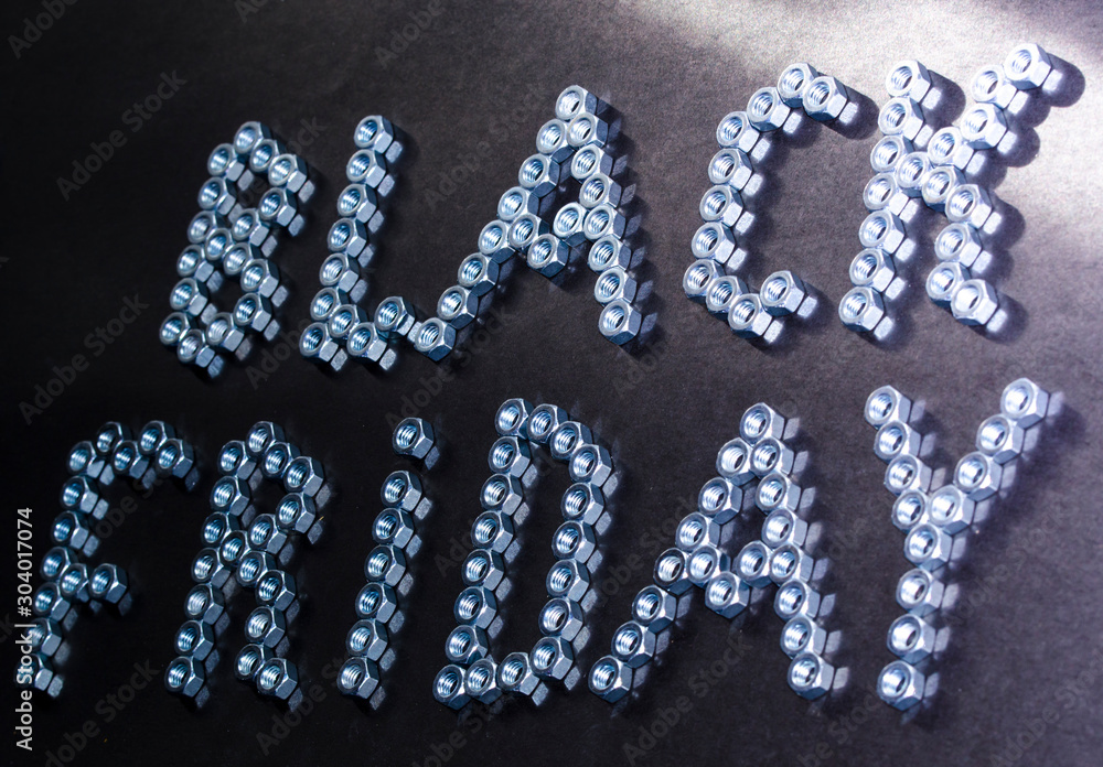 The black friday banner on matte black paper background with silver shiny metal letters lined with nuts. The black friday banner on matte black paper background with silver shiny metal letters lined with nuts.