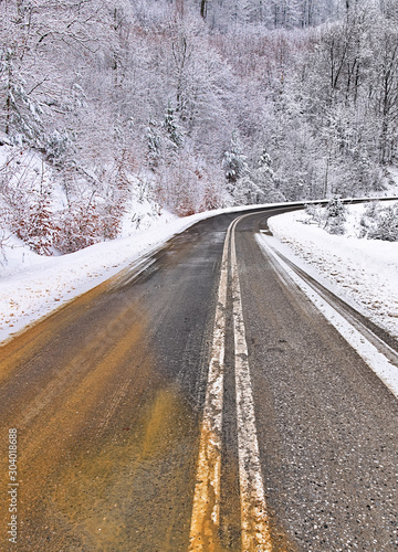 Empty asphalt road in snow covered spruce forest, beautiful winter landscape. © Kostas